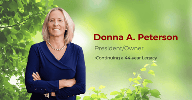 Donna Peterson, President and Owner of World Innovators, standing confidently against a natural green background.